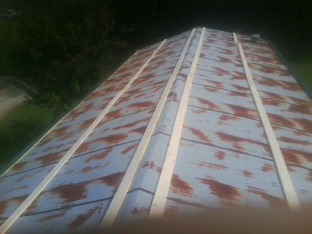 Rusted metal roof panels with new wood purlins before replacement — Storm Damage Roof Repair in Breesport by Roofing Brothers