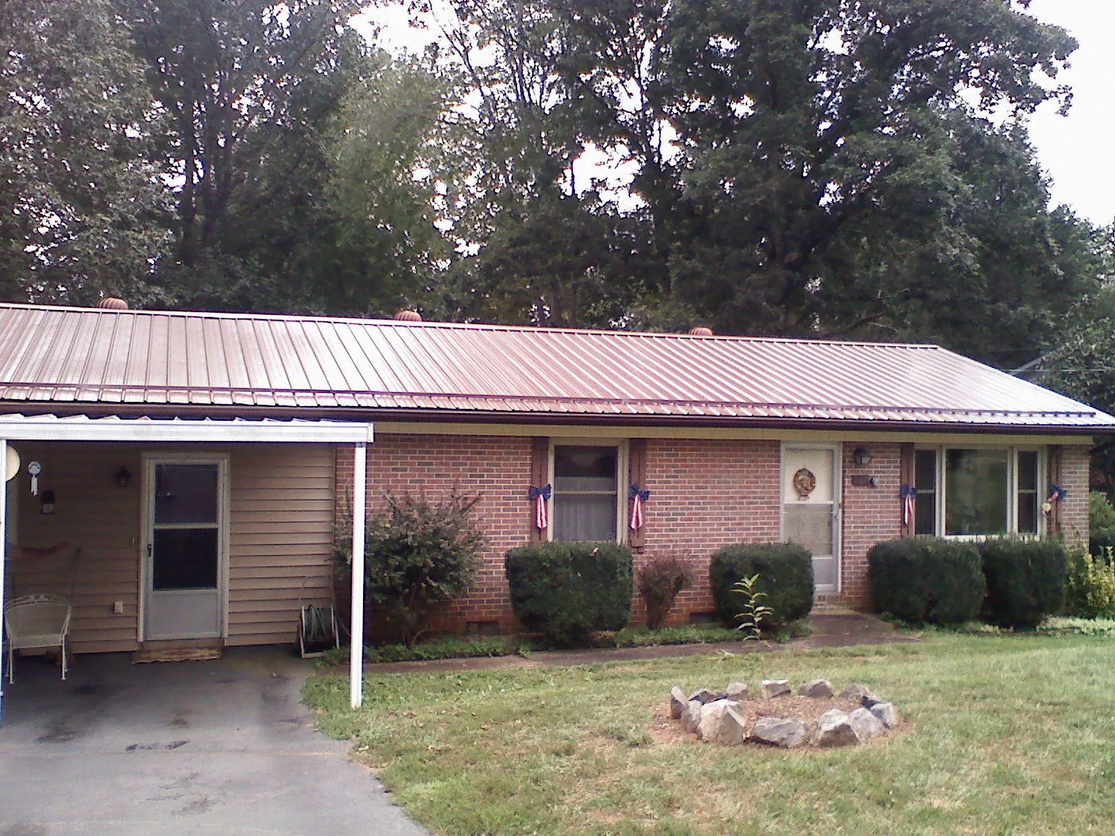 Bronze metal roof and carport on a brick ranch home — Roof Repair work by our crew in Breesport